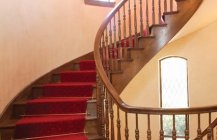 Дизайн классической винтовой лестницы в теплой цветовой гамме.